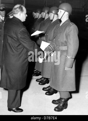 German defence minister Theodor Blank (l) hands over letters of appointment on the 9th of January in 1956 to the first soldiers of the air foce, who will start a twelve week training course in the first barracks of the new German air force in Nörvenich. Stock Photo