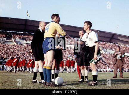 Hans Schaefer (r), captain of the German national soccer team, and Nils Liedholm (l), captain of the Swedish team, exchange their team's respective pennants prior to the kick-off of their 1958 World Cup semi-final match in front of 49,500 spectators at Ullevi Stadium in Gothenburg, Sweden on the 24th of June in 1958. Germany lost the match by a score of 1:3. Stock Photo