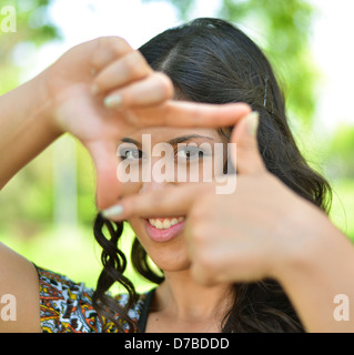 Pretty girl making frame with hands outdoors Stock Photo