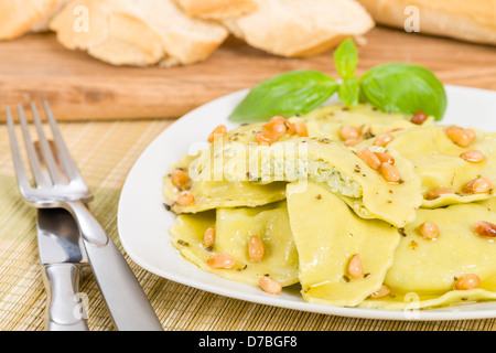 Ravioli - Italian egg and spinach pasta with basil, ricotta and pine nuts filling with brown butter, pine nuts and sage sauce. Stock Photo
