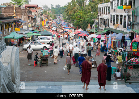 Buddhist monks and locals mix on the streets leading up to the Shwedagon Pagoda Yangon Myanmar (Burma) Stock Photo