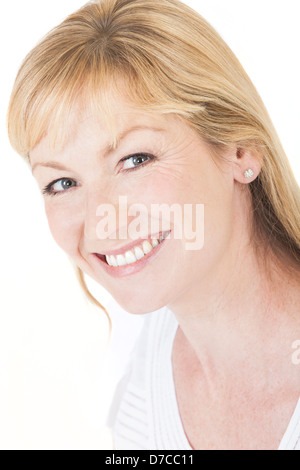 Studio portrait head shot of a happy smiling attractive middle aged blonde woman with perfect teeth Stock Photo