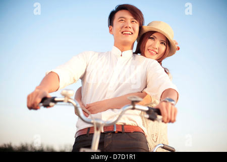 The young couple riding a bicycle Stock Photo