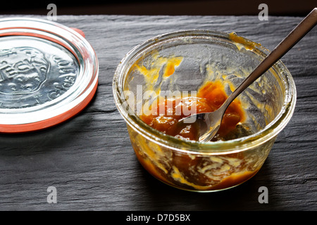 Jar of rhubarb compote or jam on slate background. Stock Photo