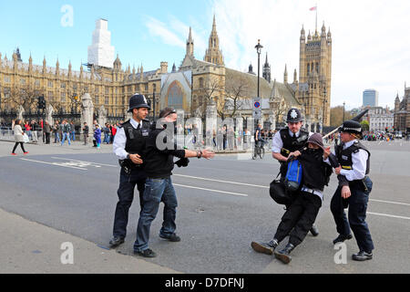 London, UK. 4th May 2013. Protestors at the Anonymous UK anti-austerity demonstration being evicted from sitting in the road by Police in Westminster by the Houses of Parliament, London, England. Credit:  Paul Brown / Alamy Live News Stock Photo