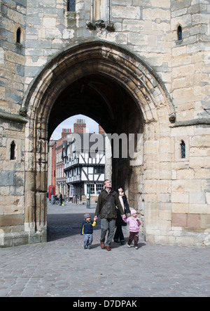 Family walking through the Exchequer gate Lincoln and looking at the cathedral Lincoln, England, UK Stock Photo