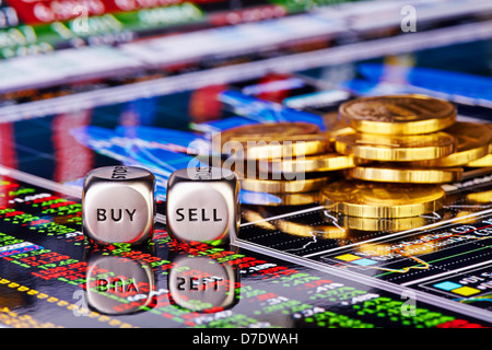 Dices cubes with the words SELL BUY, golden coins and financial chart with the columns of quotations as background. Stock Photo