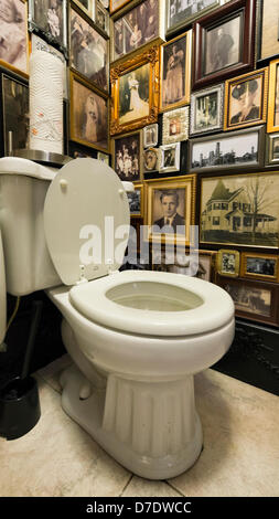 Huntington, New York, USA. 4th May, 2013. In the bathroom of fotofoto Gallery is the art installation called The American Family Gallery Project, by artist Jeffrey R. Smith, shown here during an Opening Reception at the cooperative photography gallery which is a non-profit organization. Many of the photographs used for the installation are of relatives of Smith and photo photo artists. Credit: Ann Parry/Alamy Live News Stock Photo