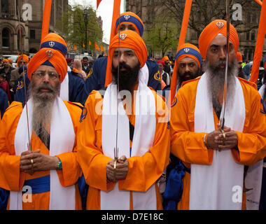Sikhs or sikkh, people associated with Sikhism, a monotheistic religion.  Mail-clad officer an Armed unformed Guard at the most important Vaisakhi celebration in the Sikh calendar  marked by their annual Nagar Kirtan orange procession, punjab, sikh, vaisakhi, religious, traditional, baisakhi, celebration, india, sikhism, ndian, punjabi, happy, turban, tradition, culture, religion, festival, through the streets of the city. The Nagar Kirtan is colour, celebration and worship and is an invitation to all men regardless of caste, religion and creed to join. Stock Photo