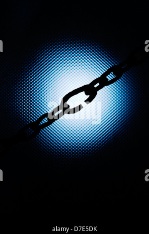 Strong metal chain in front of bright blue light Stock Photo