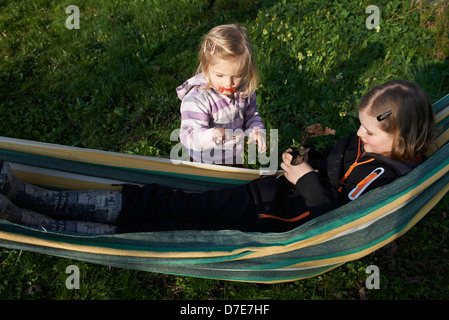 Two children blond girls resting in hammock summer time Stock Photo