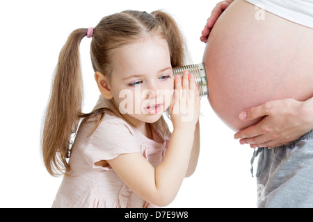 Kid girl listening with can pregnant mother's stomach Stock Photo