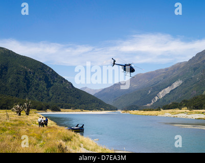 Tourists disembark from a helicopter along the Wilkins River area, Mount Aspiring National Park, New Zealand Stock Photo