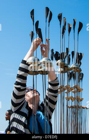 Brighton, UK. 5th May 2013. Kathy Hinde fine tunes her Sonic Reed Beds - part of 'Audible Forces' Aeolian music on the beach at Brighton Festival, Sackville Gardens Beach, Western Esplanade, Hove, East Sussex UK May 5th 2013 phot Credit: Julia Claxton/Alamy Live News Stock Photo