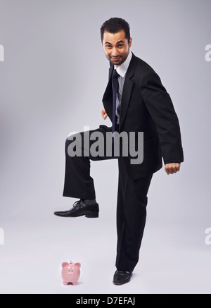 Business man about to break his piggy bank with a hammer. Isolated on ...