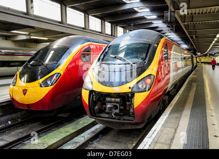 Pendolino trains operated by Virgin Trains wait at Euston Station, London, England. One appears to be undergoing maintenance. Pendolino train Stock Photo
