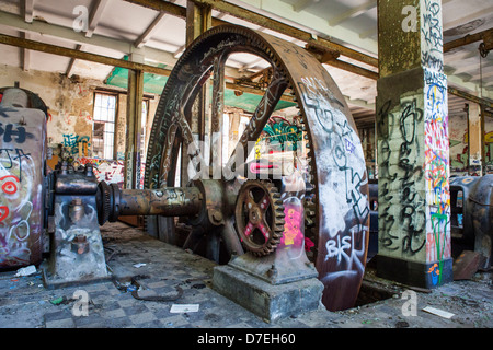 industrial heritage in abandoned former ice factory of Berlin with gears and a lot of graffiti (Germany) Stock Photo