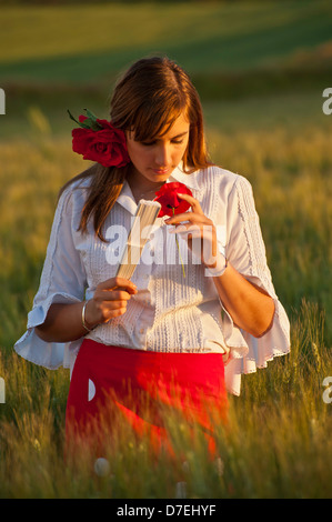 Field of wild Poppies with Spanish girl in traditional dress  Spring flowers poppy Fiesta Ferria, wild flowers Andalucia Spain Stock Photo