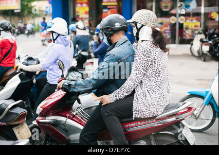 Ho Chi Minh City, Vietnam - passenger riding pillion - scooter traffic in HCMC (Saigon) Stock Photo