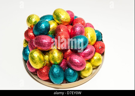 Colored chocolate Easter eggs packed in a pile on a dish, isolated on a white background Stock Photo