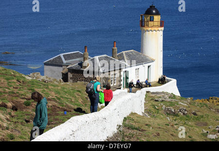 Visitors to the Isle of May in the Firth of Forth approach the Low Light, one of the islands three lighthouses which was operational between 1844 - 1887. It is now used by the Observatory Trust whose volunteers stay here and study the thousands of migrating birds that land here during their long journeys. Credit: Picture Scotland/Alamy Live News Stock Photo