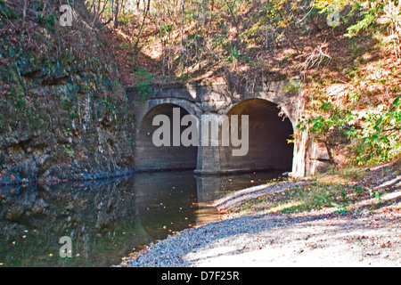 Fifteen Mile Creek flowing through duel stone culverts under an abandoned railroad near Chesapeake and Ohio Canal Aqueduct. Stock Photo