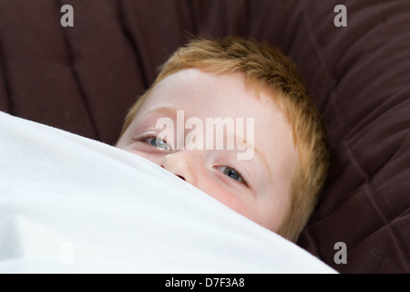 little boy peeping from under the duvet cover Stock Photo - Alamy