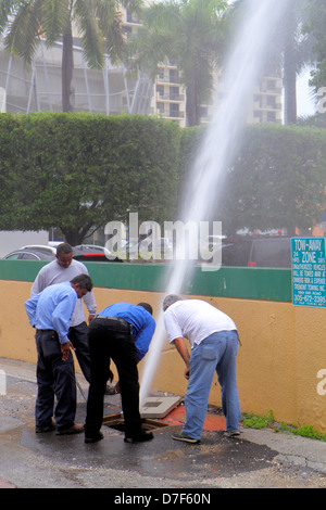 Miami Beach Florida,city water main,pipe,break,broken,loss of pressure,leak,spewing,employees,man men male adult adults,Black African Africans,Hispani Stock Photo