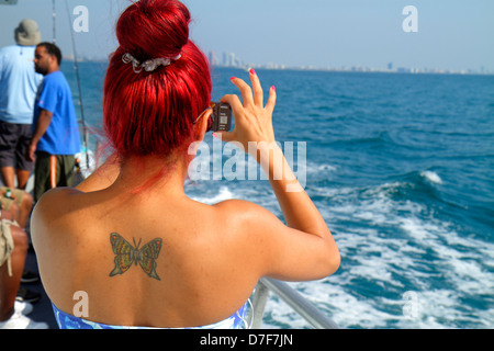 Miami Beach Florida,Atlantic Ocean water water,charter fishing boat,inflight,passenger cabin,adult adults woman women female lady,tattoo,butterfly,hai Stock Photo