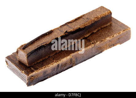 A 10 grams piece Hashish laid on top 20 grams piece isolated on white background. This pieces represent quantity three retail Stock Photo