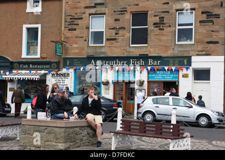 Group of young people outside eating fish and chips from the award winning Anstruther Fish Bar in Fife Scotland Stock Photo