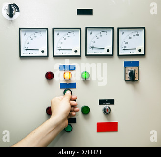 Electricity distribution controller & testing unit. An adult man's hand ...