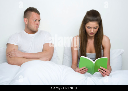 Young couple sitting up in bed. Stock Photo