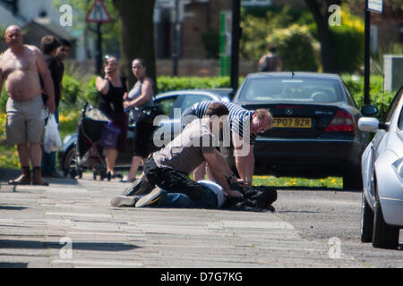 London, UK. 7th May 2013 Members of the public apprehend one of two muggers who snatched jewelery from a man pushing his child in a pushchair on Wood End Lane, Northolt. Police then arrived and led the man away. Credit: Martyn Wheatley/Alamy Live News Stock Photo