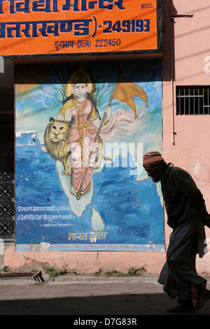 A local man walks past a mural of India in the bazaar in Uttarkashi. Stock Photo