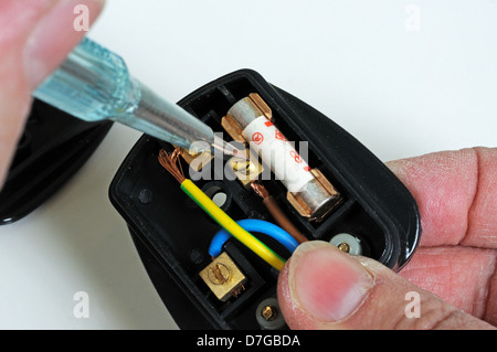 Man wiring English 3 pin 13 amp plug - inserting live wire, England, UK, Western Europe. Stock Photo