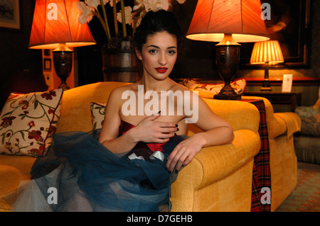 A young woman sat on a sofa in the hotel drawing room Stock Photo