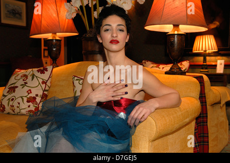 A young woman with attitude sat on a sofa in the hotel drawing room Stock Photo