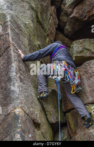 Male climber bridging on Flying Buttress Gully - Diff at Stanage Edge Stock Photo