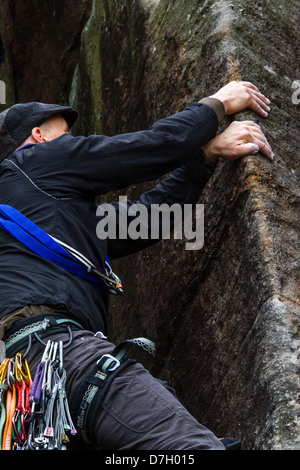 Male climber ascends an arête on Wedge Rib - VS 5a - The Flying Buttress area of Stanage Edge Stock Photo