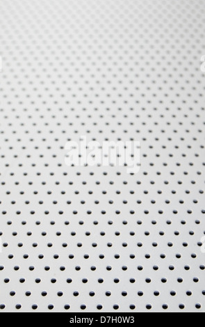 background texture with holes in metal with selective focus in the foreground Stock Photo