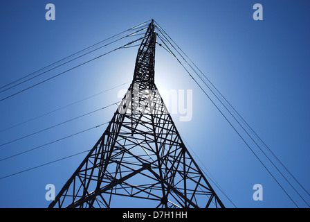 High voltage metal tower with glass insulators on blue sky Stock Photo