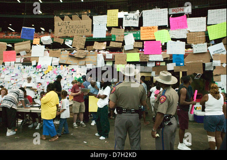 Hurricane Katrina survivors from New Orleans search the message board for loved ones after being relocated to a Red Cross shelter in the Houston Astrodome September 4, 2005 in Houston, TX. Stock Photo
