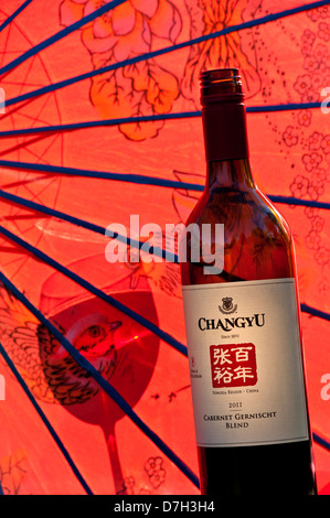 Bottle of 2011 Chinese 'Changyu' Cabernet Gernischt red wine from Ningxia region China with oriental umbrella and glass shadow Stock Photo
