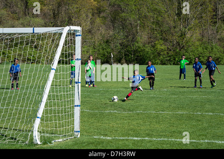 Young boy takes a penalty kick during soccer match. Stock Photo
