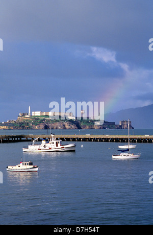 fishing boats at anchor in Aquatic park at fisherman's wharf with rainbow over alcatraz after a storm Stock Photo