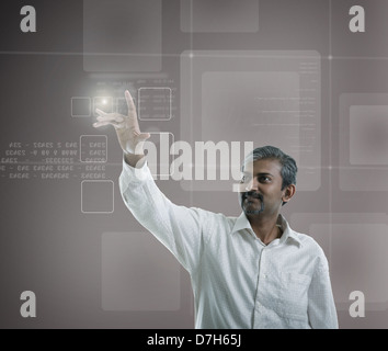 asian indian businessman pressing high tech type of modern buttons on a virtual background Stock Photo