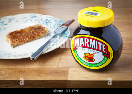 Bath, UK - September 25, 2011: A pot of Marmite on a wooden kitchen surface with toast in the background. Stock Photo