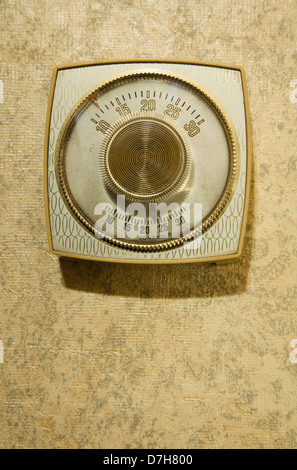 old fashioned gold and cream thermostat and wallpaper Stock Photo