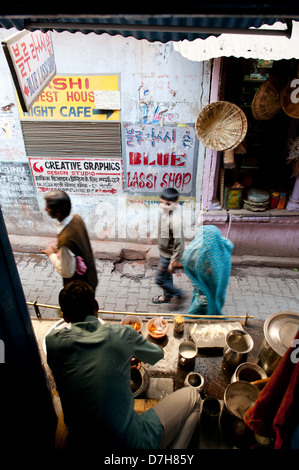 People walk past the famous Blue Lassi Shop in the alleys of Varanasi not far from the River Ganges. India Stock Photo